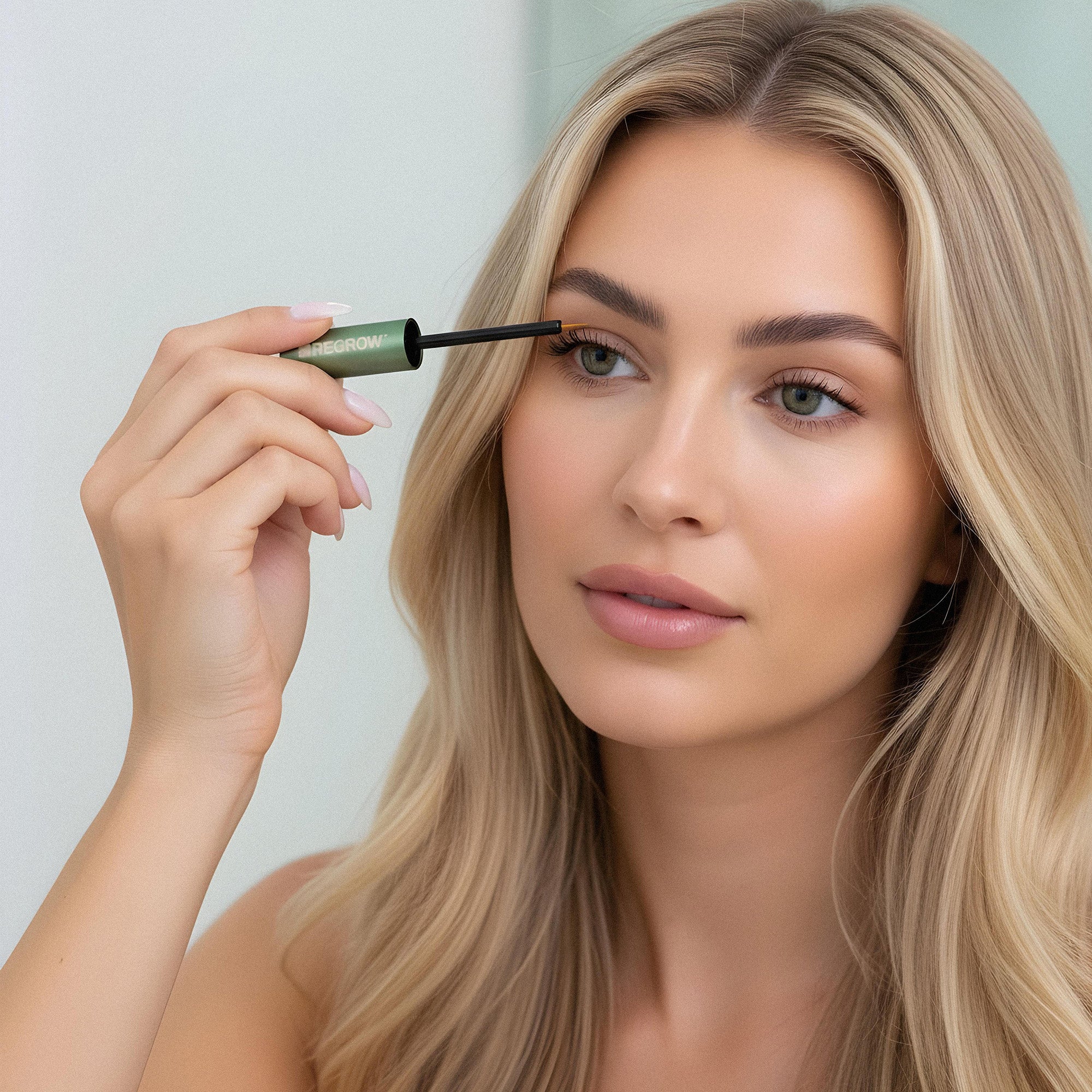 Woman applying mascara with a clear background